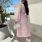 Robe fleurie tendance à manches longues, accentuant la taille, avec col en V et patte de boutonnage